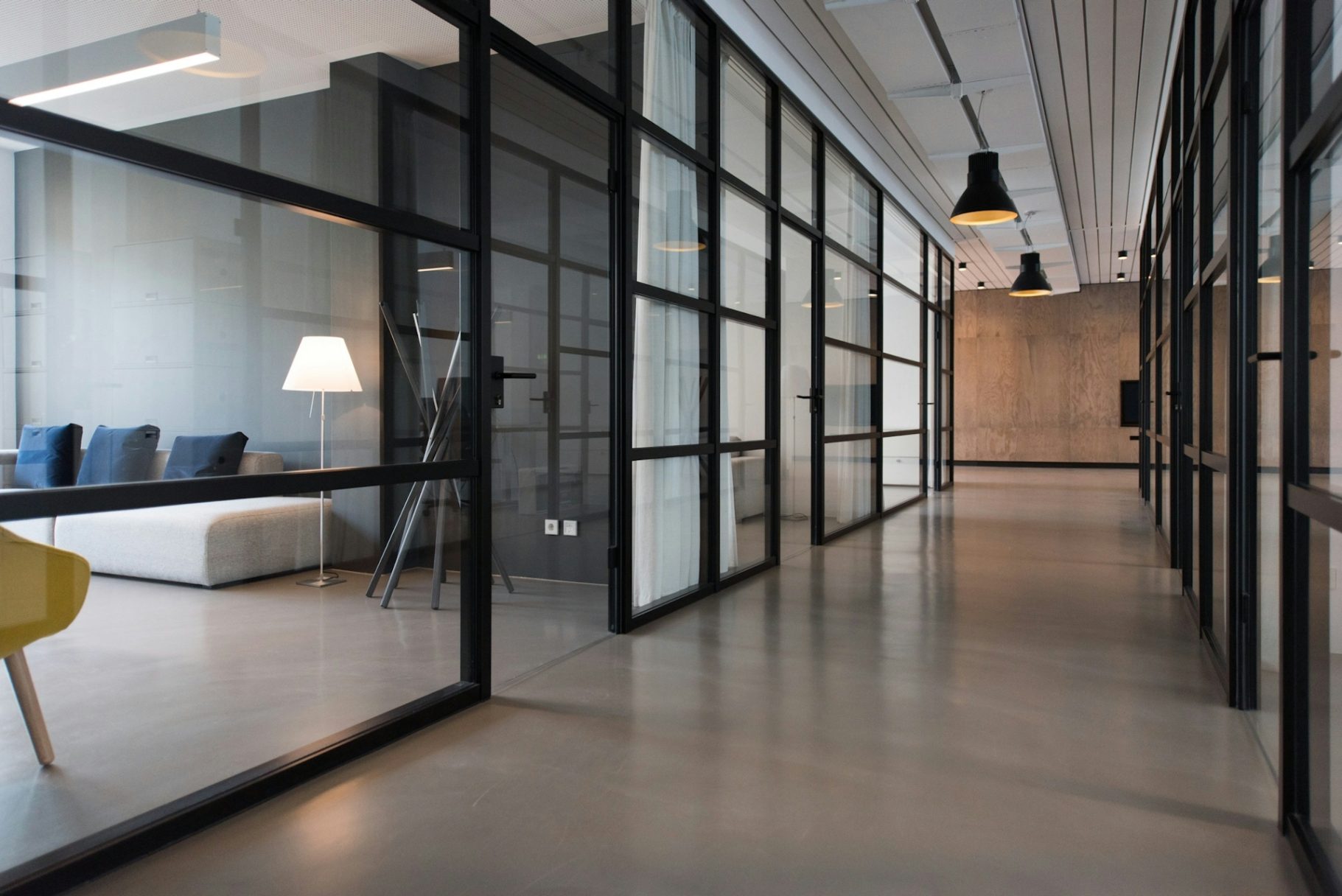 Gebäude- und Unterhaltsreinigung Modern Büroumgebung mit Glaswänden und minimalistischer Einrichtung.